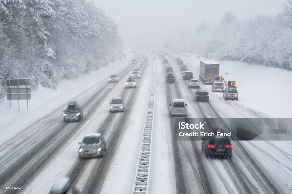 snow covered highway in austria with cars out of focus slippery highway in wintertime Winter Stock Photo