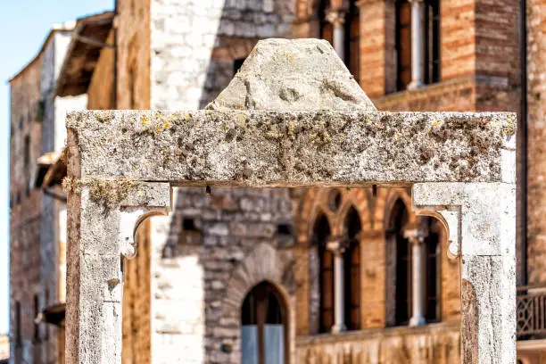 San Gimignano, Italy closeup of ancient stone well in Piazza square in town village in Tuscany during sunny summer