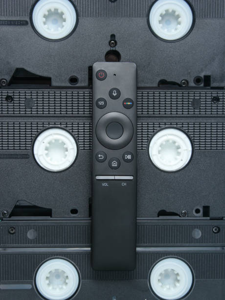 istock Modern TV remote on background of video cassettes. 1127835596