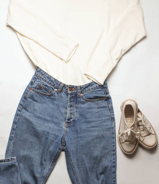istock Female sweater, jeans, sneakers on a white background, top view 1127836785