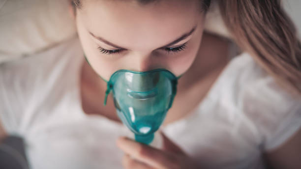 Daily Asthma Care Young woman in a process of healing.  Daily asthma care. Very Shallow DOF. Developed from RAW; retouched with special care and attention; Small amount of grain added for best final impression. medical ventilator photos stock pictures, royalty-free photos & images