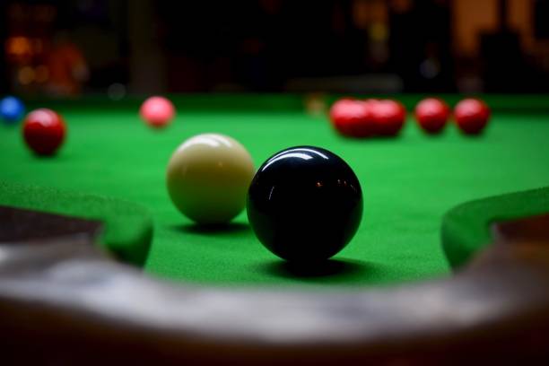 Snooker table with balls A snooker table full of balls in red, white and black with a black ball in front of a pocket billard queue stock pictures, royalty-free photos & images