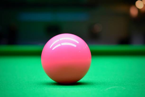 Pink Snooker Ball Pink Snooker Ball lying on a green Snooker table billard queue stock pictures, royalty-free photos & images