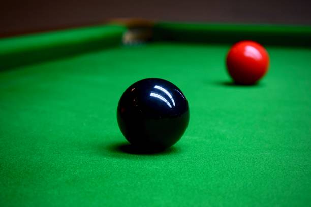 Black and red Snooker balls Black and red snooker balls on a green billard table in front of a pocket billard queue stock pictures, royalty-free photos & images