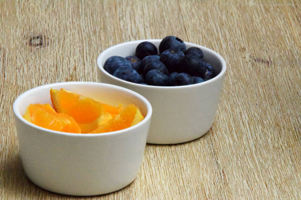istock Fresh blueberries and orange slices 1127839273