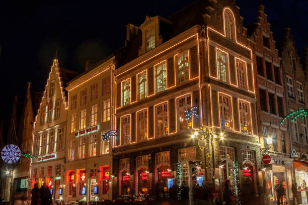 Brugge, Belgium - April 1, 2014: Brugge at night with tourists and restaurants at the center square.