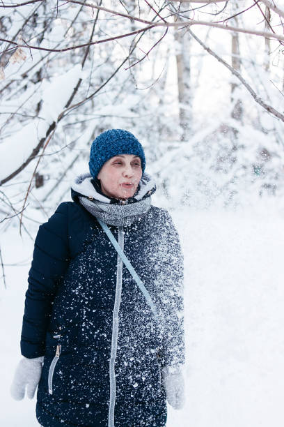istock Beautiful mature playing with snow in the forest 1127841554