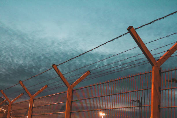 istock Iron fence with barbed wire during blue hour 1127841699