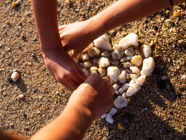 istock Human hands making heart shape of white rocks 1127842913