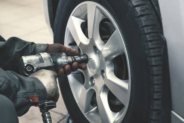 istock Replacing tires using pneumatic wrench tool by mechanic worker after balancing wheels in car service garage shop 1127842933