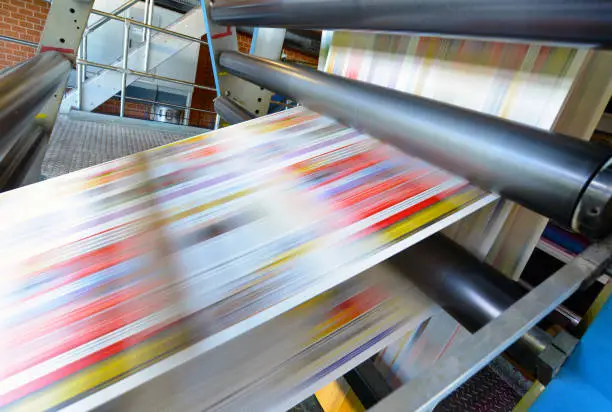Photo of printing of coloured newspapers with an offset printing machine at a printing press