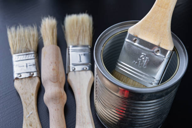 istock Brushes for painting with paint and cans on a workshop table. Painting accessories prepared for painting. 1127851474