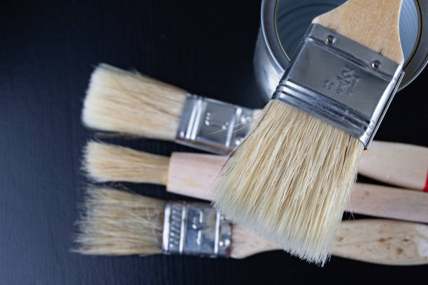 istock Brushes for painting with paint and cans on a workshop table. Painting accessories prepared for painting. 1127851704