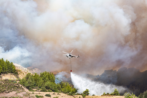 Helicopter dropping water for fire fighting