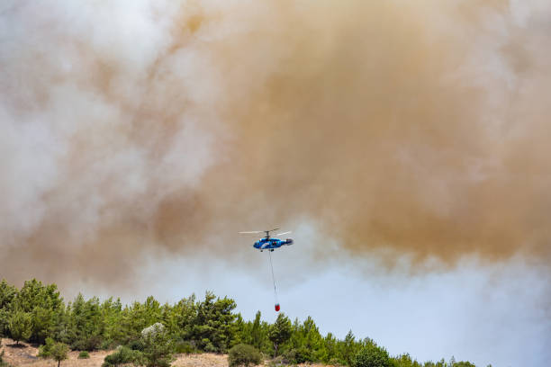 istock Helicopter carrying water tank for fire fighting 1127853625