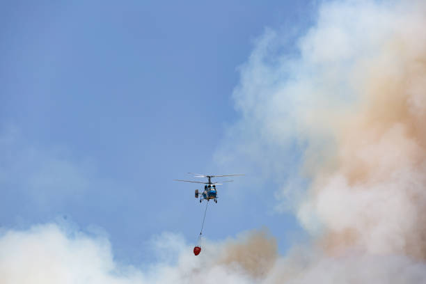 istock Helicopter carrying water tank for fire fighting 1127856358