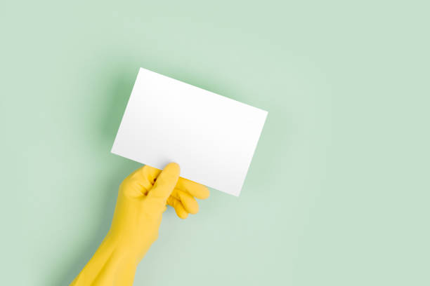 istock Hands in yellow gloves hold empty card. 1127856387