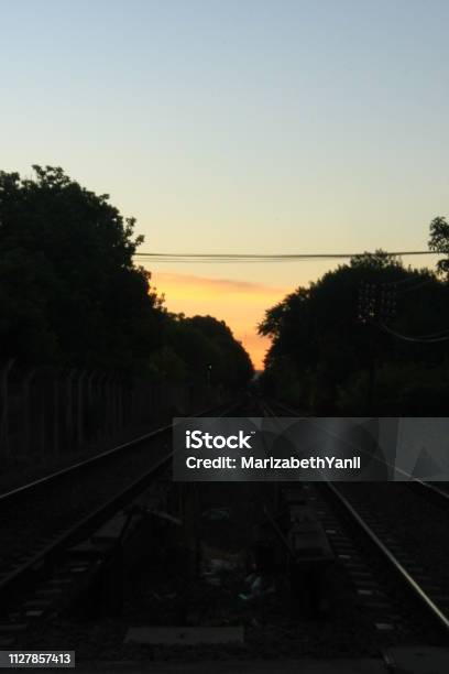 Views Of Train Track In Front With Sunset In The Background Stock Photo - Download Image Now