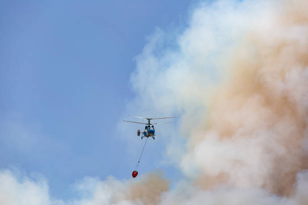 istock Helicopter carrying water tank for fire fighting 1127857736