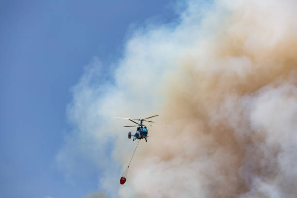 istock Helicopter carrying water tank for fire fighting 1127858072