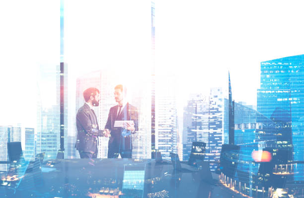 istock Men shake hands in meeting room, cityscape 1127865562