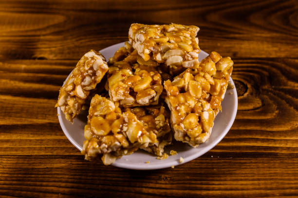 istock Ceramic plate with peanut brittles on wooden table. 1127867822