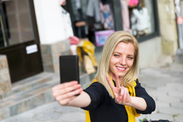 istock Cute young smiling girl is making selfie. 1127870097