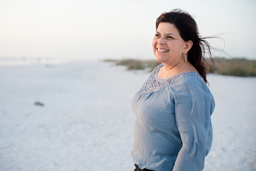 Portrait of mature hispanic woman on the beach