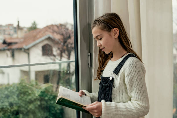 istock Child reading book at home. 1127875376