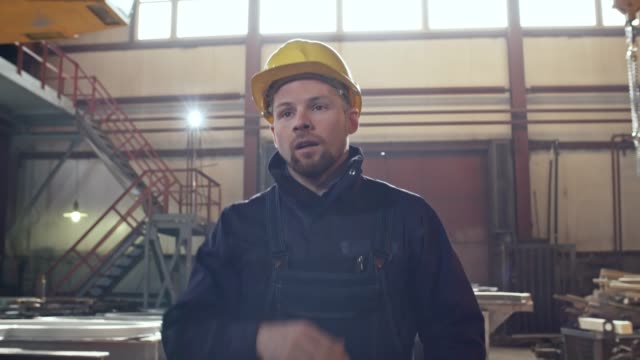 Tired Worker Walking through Metal Fabrication Plant