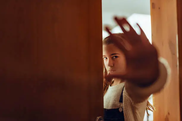 Girl with pigtails in shadow with hand up in stop gesture