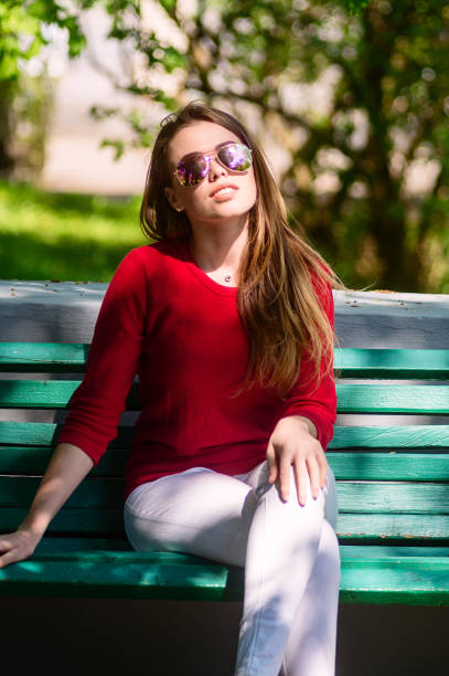 istock Girl in glasses sitting on the bench. 1127878402