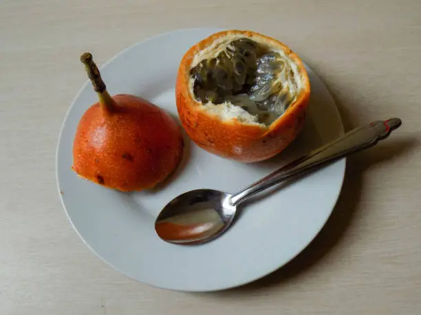 The photo shows one of these fruits served on a plate and with cutlery.