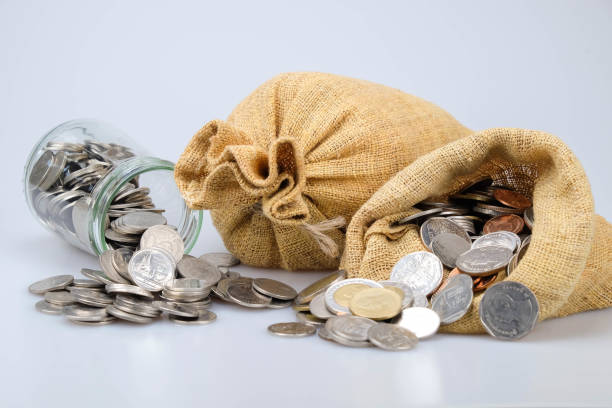 istock Close-Up Of Sack And Coins Against White Background 1127879132