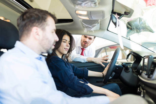 istock Female Customer Examining Car Interiors With Boyfriend 1127882303