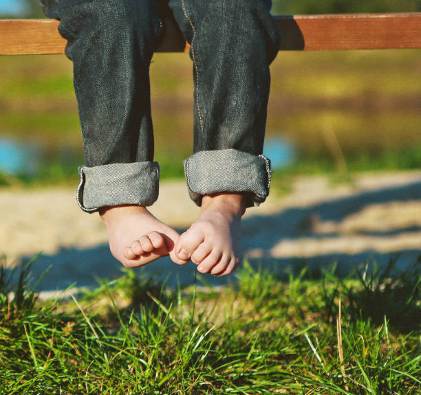 istock spring baby park park bench bare feet grass 1127887833
