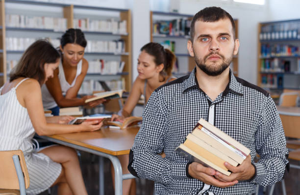 istock Male student with pile of books 1127887972
