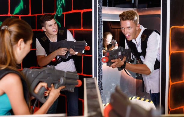 istock Two laser tag teams playing enthusiastically and aiming at each other in dark room 1127888045