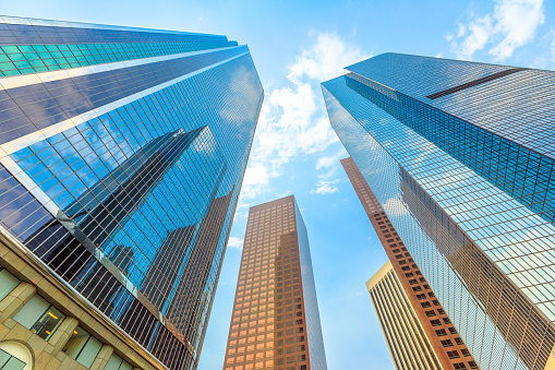 Architecture background. Sky blue glass high-rise reflective facade. Glass of a high rise buildings. Los Angeles Downtown, California, United States. Sunny day in blue sky.