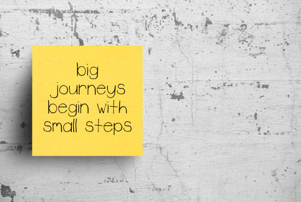 Sticky note on concrete wall, Big journeys begin with small steps