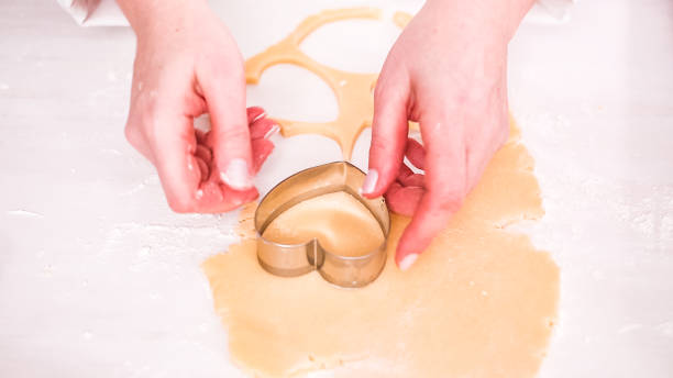 istock Cutting out shapes from sugar cookie dough with cookie cutters. 1127895638