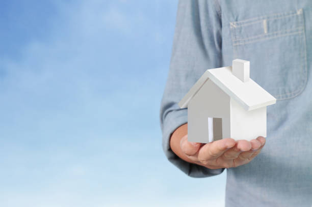 istock Mortgage concept by house from hand 1127898226