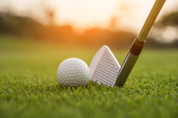 istock Golfer is putting golf ball on green grass at golf course for game with blur background and sunlight ray. 1127900791