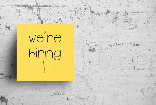 istock Sticky note on concrete wall, We're Hiring 1127900815