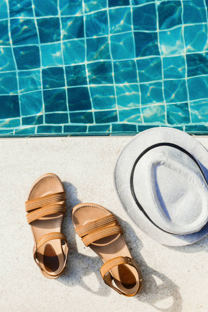 istock Vacation flat lay with woman's sandals and hat front of the pool 1127906049