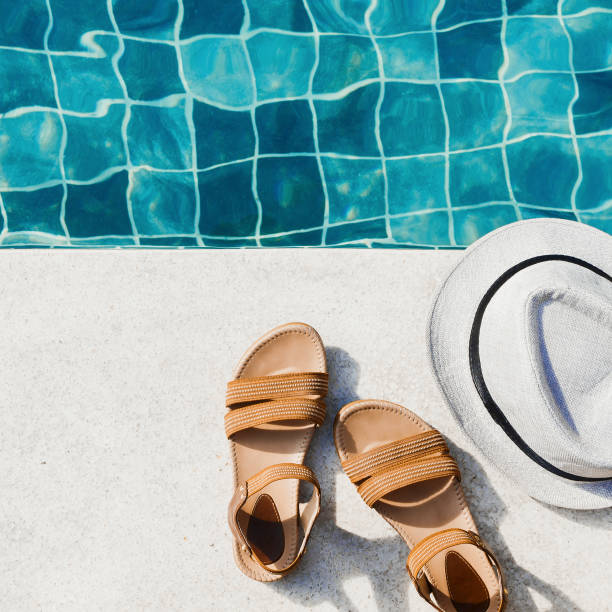 istock Vacation flat lay with woman's sandals and hat front of the pool 1127906050