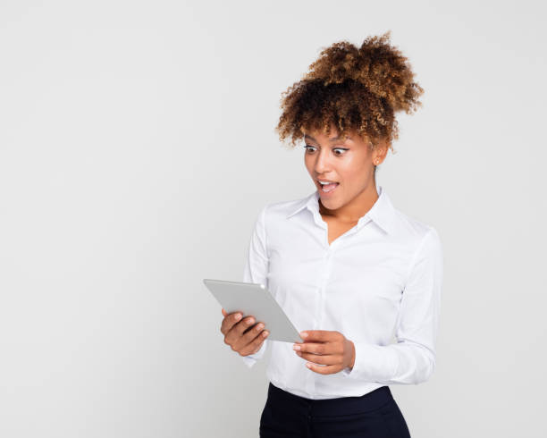 istock Surprised young businesswoman with tablet pc 1127908429