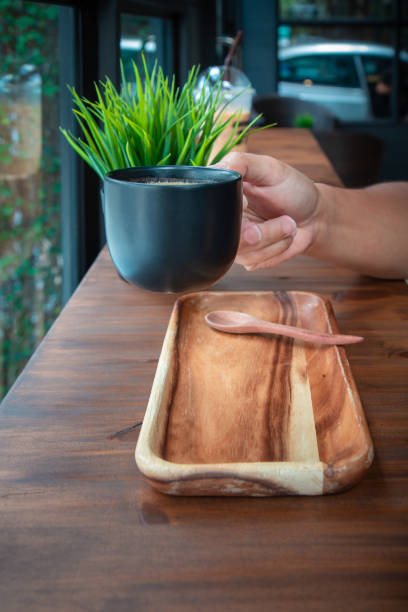 Cup coffee with hand on the table in coffee shop
