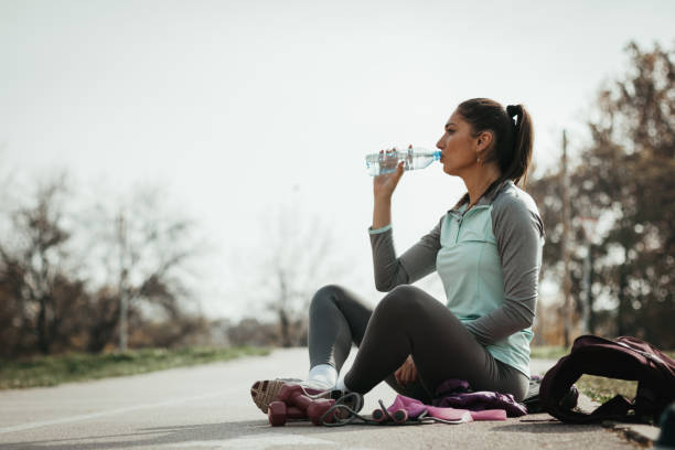 istock Young female athlete relaxing after the training and drinking water 1127908730