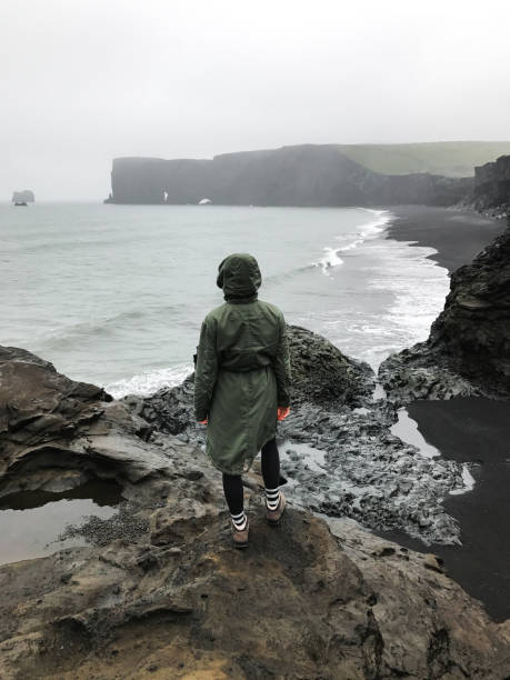 istock Wanderlust explorer discovering icelandic natural wonders. Basalt rock on black sand beach as known as Reynisfjara beach in the south coast of Iceland in fog and cloudy day. 1127908891